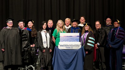 Group stands together showing off a gift
